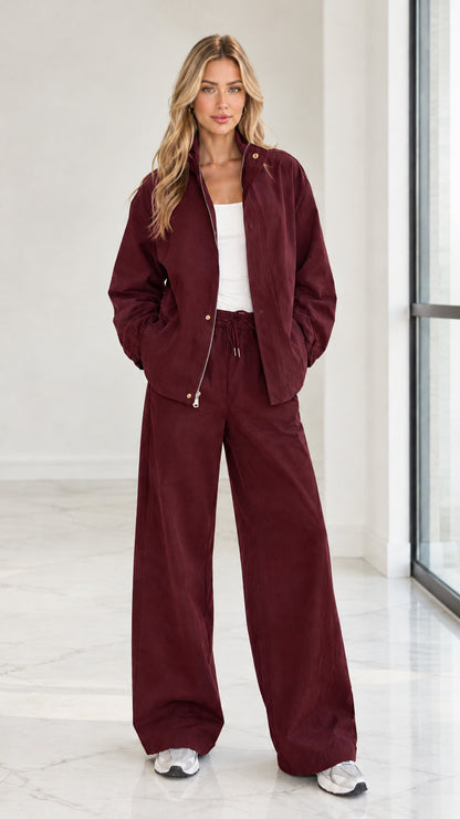 Full front view of woman wearing burgundy 2-piece zip jacket and wide leg pants set