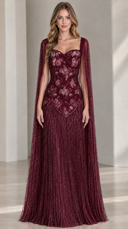 Model wearing burgundy wine red cape sleeve fringe formal dress