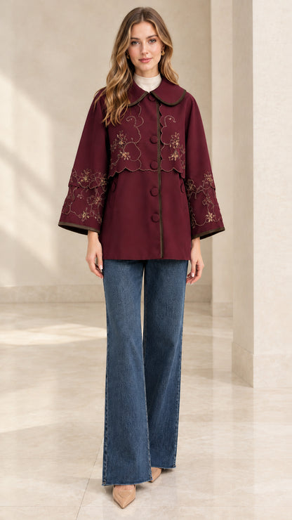 Full-length front view of woman wearing burgundy wine embroidered scalloped capelet jacket